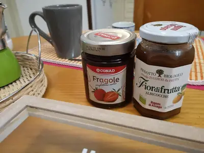 two jars of peanut butter and strawberry jam on a counter at A casa di Zara in Termini Imerese