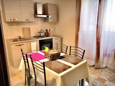 a kitchen with a table with chairs and a kitchen with a sink at I babbaluci in Palermo