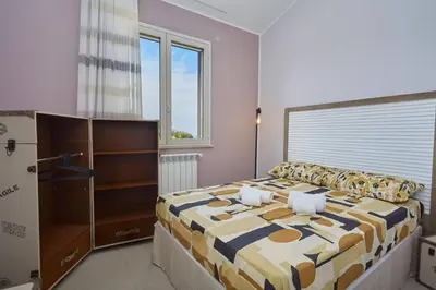 a bedroom with a large bed and a large window at Villa Biancolilla in Castellammare del Golfo
