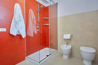 a bathroom with a toilet and a glass shower at Villa Biancolilla in Castellammare del Golfo
