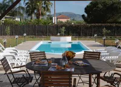a table with food on it next to a swimming pool at RESORT Valle del Re in Partinico