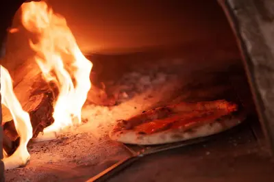 two pizzas are cooking in a brick oven at RESORT Valle del Re in Partinico