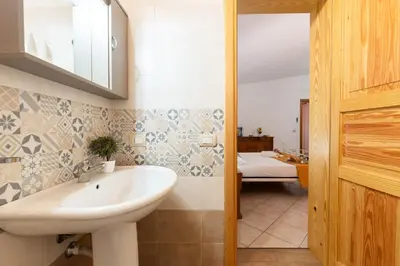 a bathroom with a sink and a bed in a room at Villa Minoa con piscina in San Vito lo Capo