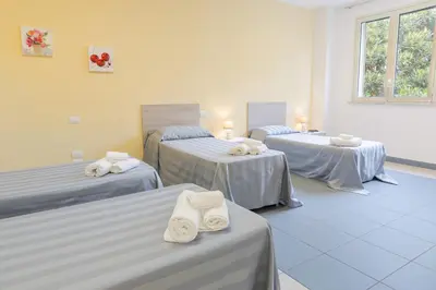 a room with three beds with towels on them at Casa per Ferie Don Orione Palermo in Palermo