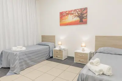 a bedroom with two beds and two night stands at Casa per Ferie Don Orione Palermo in Palermo