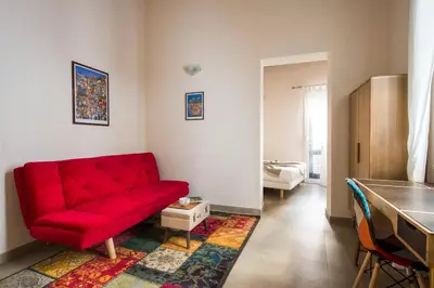 a living room with a red couch and a rug at Santa Cecilia Apartment by Wonderful Italy in Palermo