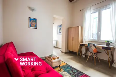 a living room with a red couch and a desk at Santa Cecilia Apartment by Wonderful Italy in Palermo