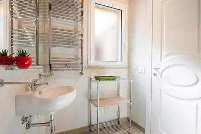 a white bathroom with a sink and a window at Santa Cecilia Apartment by Wonderful Italy in Palermo