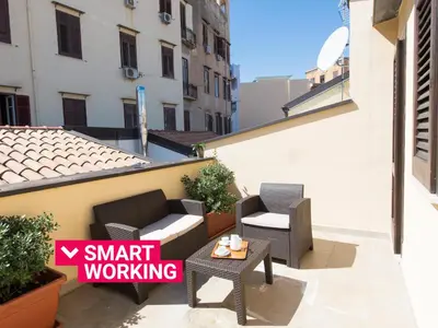 a small balcony with two chairs and a table at Santa Cecilia Apartment by Wonderful Italy in Palermo