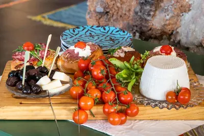 a tray of food with tomatoes and doughnuts on a table at Il Giardino di Ballarò Boutique B&B in Palermo