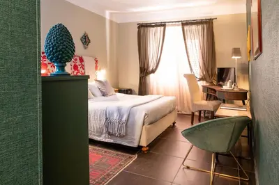 a bedroom with a bed and a desk and a chair at Il Giardino di Ballarò Boutique B&B in Palermo