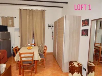 a dining room with a table and chairs in a room at Loft CASA PROFESSA 1 in Palermo