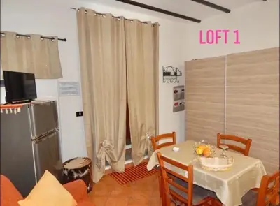 a dining room with a table and a television at Loft CASA PROFESSA 1 in Palermo