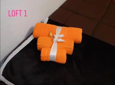 a stack of orange towels with a bow at Loft CASA PROFESSA 1 in Palermo