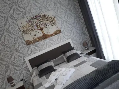 a bedroom with a bed with a tree on the wall at A casa di Simona in Monreale