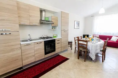 a kitchen and dining room with a table and a red couch at A casa di Simona in Monreale