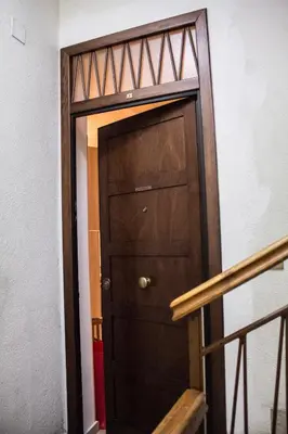 a wooden door in a room with a staircase at La Casita 24 in Palermo