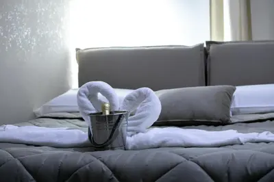 a bedroom with a bed with towels and a candle at ALBA DEL CAPO in Palermo