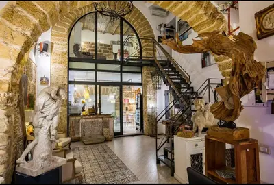 a lobby with a staircase and statues in a building at Porta di Castro Hotel & SPA in Palermo