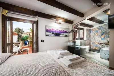 a bedroom with a large bed and a bathroom at Porta di Castro Hotel & SPA in Palermo