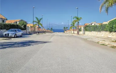 an empty street with a car parked on the side of the road at Villa Joly in Terrasini