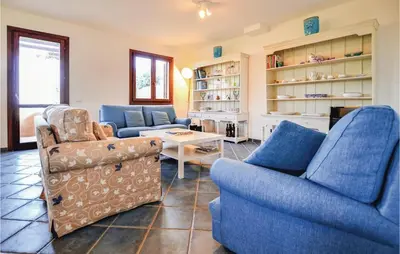 a living room with two blue chairs and a table at Villa Joly in Terrasini