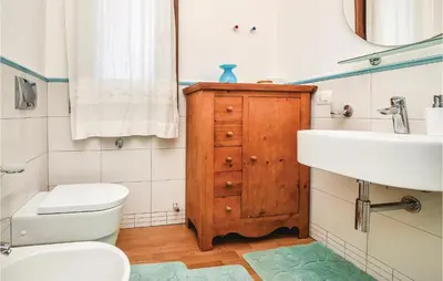 a bathroom with a white toilet and a sink at Villa Joly in Terrasini