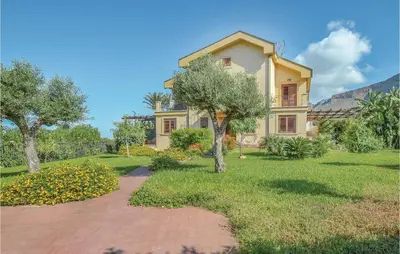 a house with a pathway in front of a yard at Villa Joly in Terrasini