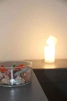 a bowl of rocks on a table next to a candle at Mamiani Suite in Castellammare del Golfo