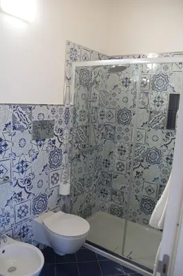 a blue and white bathroom with a toilet and a shower at Mamiani Suite in Castellammare del Golfo