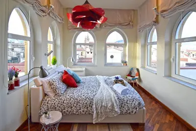 a bedroom with a bed in a room with windows at Casa Santa Sofia in Palermo