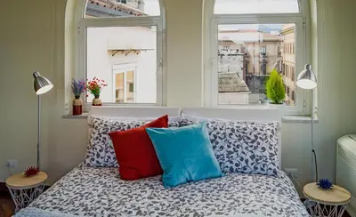 a bedroom with a bed with pillows and a window at Casa Santa Sofia in Palermo