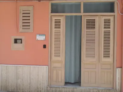 a house with a window and a door with a curtain at Short Lets Vacanze 