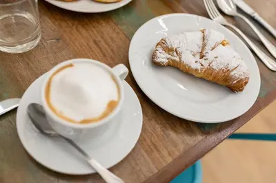 a table with a plate of food and a cup of coffee at Ai Tre Mercati in Palermo