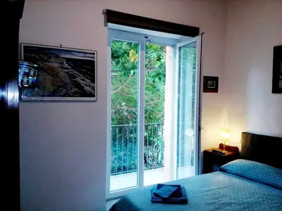 a bedroom with a bed and a large window at Arimatea Accommodations in Palermo