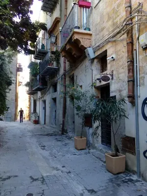 a man walking down a street in an alley at Arimatea Accommodations in Palermo