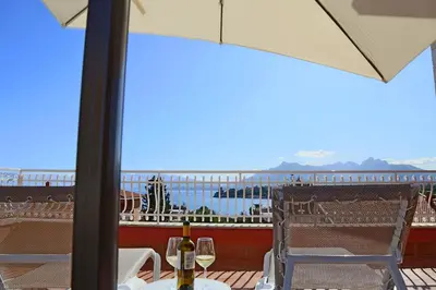 a table with a bottle of wine on a balcony at Villa Edera Rental Room in Santa Flavia