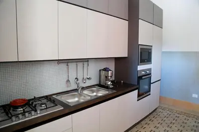 a kitchen with white cabinets and a sink at Villa Edera Rental Room in Santa Flavia