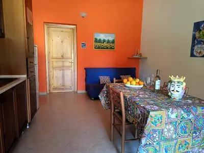 a kitchen with a table with a bowl of fruit on it at Villette di Scopello - Casa Vacanze in Scopello