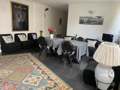 a living room with tables and chairs and a rug at Dolce Vita casa vacanze in Carini