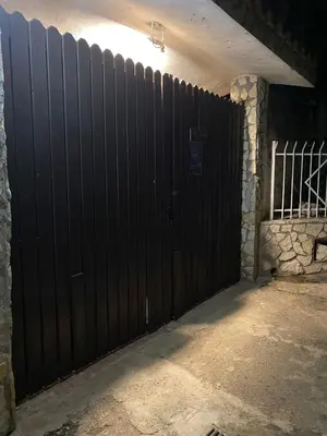 a black gate in a garage with a stone wall at Dolce Vita casa vacanze in Carini