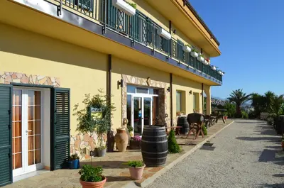 a yellow building with a balcony and a patio at Villa della Mimosa in Alia