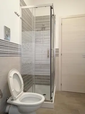 a bathroom with a toilet and a glass shower at Casagioiosa18 in Palermo