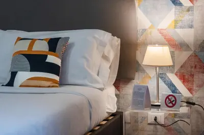 a bedroom with a bed with pillows and a lamp at casa mo room and suite in Palermo