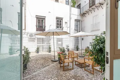 a patio with tables and umbrellas in a building at Torremuzza Homes by Wonderful Italy in Palermo