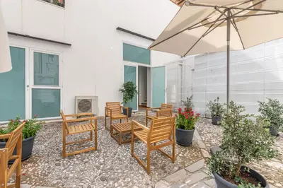 a patio with chairs and an umbrella at Torremuzza Homes by Wonderful Italy in Palermo