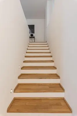 a staircase with white walls and wooden floors at Torremuzza Homes by Wonderful Italy in Palermo