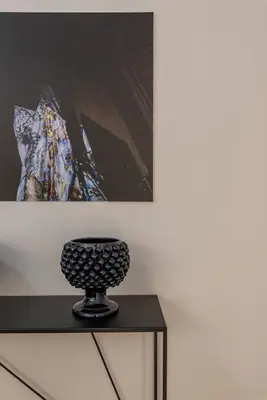 a black vase sitting on top of a table at Torremuzza Homes by Wonderful Italy in Palermo