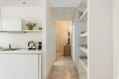 a kitchen with white cabinets and a hallway at Torremuzza Homes by Wonderful Italy in Palermo