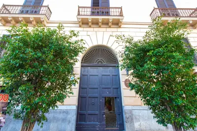 a blue door on a building with two trees at Torremuzza Homes by Wonderful Italy in Palermo